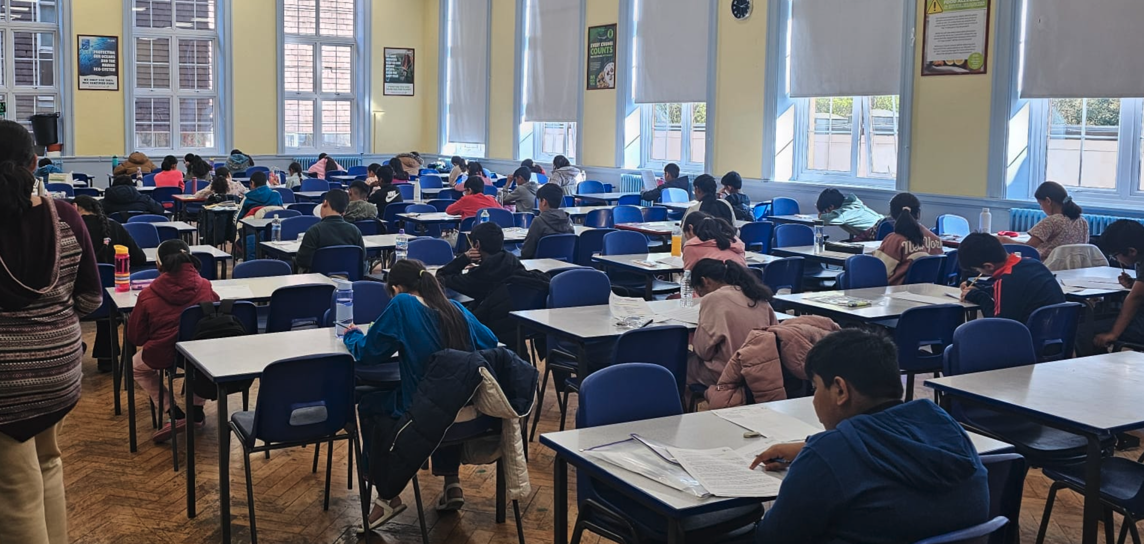 Children seated in rows during a GLECTA 11+ mock test session, viewed from the back of the classroom